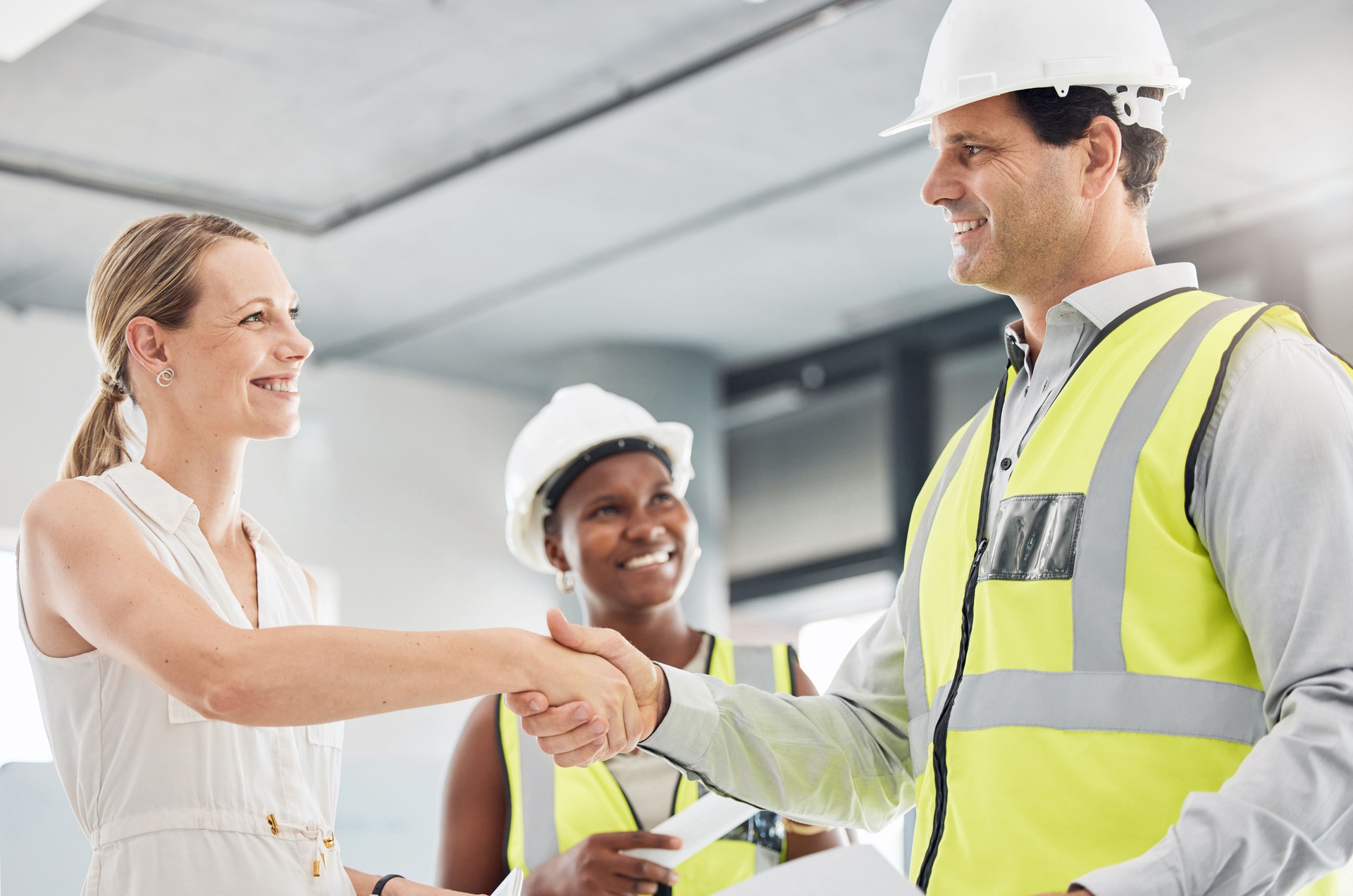 Welcome handshake and meeting with construction engineer for business contract deal together. Professional agreement hand gesture with industrial architect design workers busy with project.